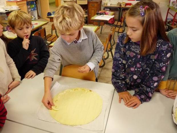 César s'applique pour étaler les pommes sur la pâte.